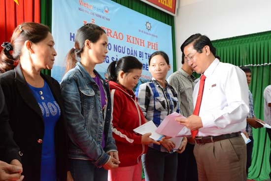 Lãnh đạo VietInBank Quảng Ngãi trao tiền hỗ trợ cho ngư dân, gia đình các ngư dân.