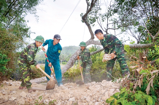 Cán bộ, chiến sĩ Bộ đội Biên phòng giúp nhân dân sửa chữa đường giao thông nông thôn.