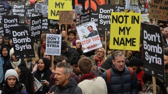 Những người biểu tình giơ khẩu hiệu phản đối việc Anh không kích IS. Ảnh: BBC
