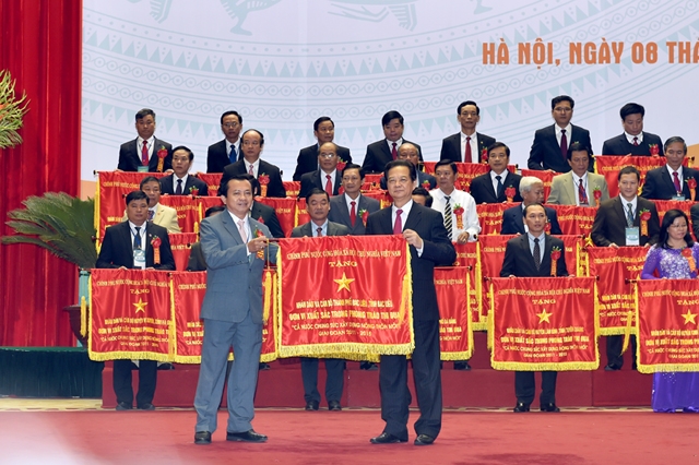 Thủ tướng Nguyễn Tấn Dũng trao tặng Cờ thi đua của Chính phủ cho 41 tập thể cấp huyện dẫn đầu trong phong trào xây dựng NTM. Ảnh: VGP/Nhật Bắc.