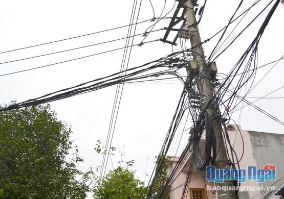 Sau khi chỉnh trang, cáp viễn thông treo trên cột điện tại đường Lê Lợi (TP.Quảng Ngãi) vẫn chưa đảm bảo mỹ quan.