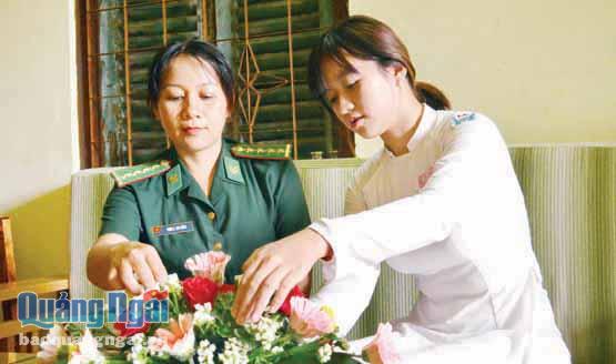 Chị Phan Thị Thu Hằng cùng với con gái cắm hoa chào đón ngày 8.3. Ảnh: K. TOÀN