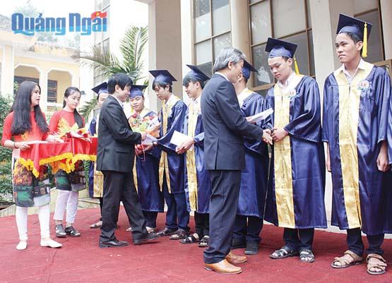 Phó Chủ tịch Thường trực UBND tỉnh Lê Quang Thích (bên phải) khen thưởng cho học sinh đạt giải Học sinh giỏi cấp quốc gia năm 2016.                                                                        Ảnh: TRỊNH PHƯƠNG