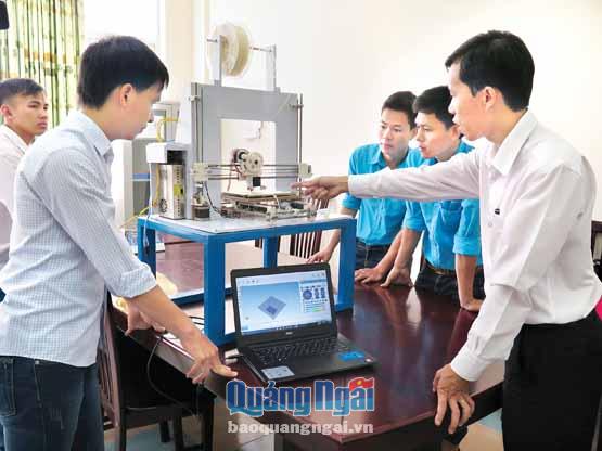 Sinh viên Lê Lâm (bên trái) và thầy giáo Trần Thanh Tùng (bên phải) giới thiệu mô hình in 3D cho các sinh viên Trường ĐH Phạm Văn Đồng.