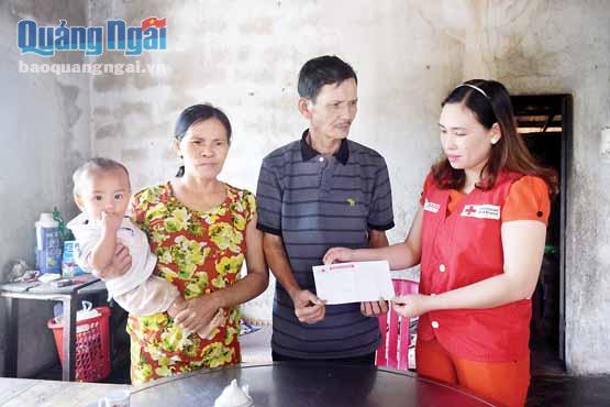Chị Huỳnh Thị Thùy Trang trao tiền hỗ trợ cho gia đình ông Dương Tấn Dũng, ở xã Đức Tân (Mộ Đức).