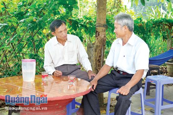 Ông Bình (bên trái) cùng với trưởng thôn Minh Thành đang bàn việc chuẩn bị cho công tác bầu cử sắp tới.