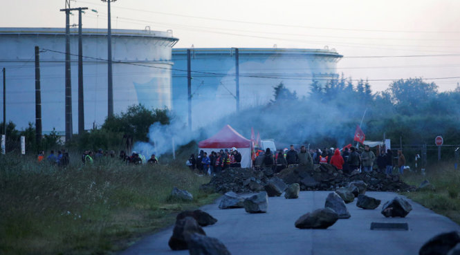 Công nhân và người biểu tình Pháp tập trung gần một khu vực rào chắn dựng lên trên lối vào kho xăng dầu gần nhà máy lọc dầu tại Donges - Ảnh: Reuters