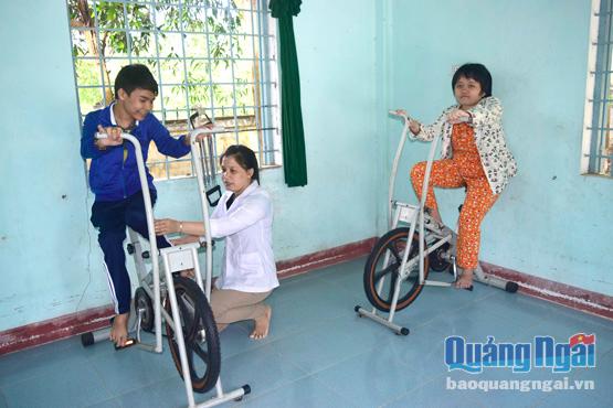 Chị Nguyễn Thị Kim Hương hướng dẫn tập phục hồi chức năng cho các nạn nhân chất độc da cam.