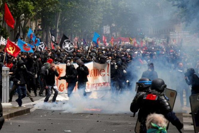  Đám đông biểu tình mặc đồ đen và đeo mặt nạ đụng độ với cảnh sát chống bạo động ngay trên đường phố Paris ngày 14-6 - Ảnh: Reuters