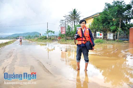 Phóng viên Lê Đức tác nghiệp đưa tin về lũ lụt ở xã Hành Thiện, huyện Nghĩa Hành năm 2013.                                    Ảnh: PV