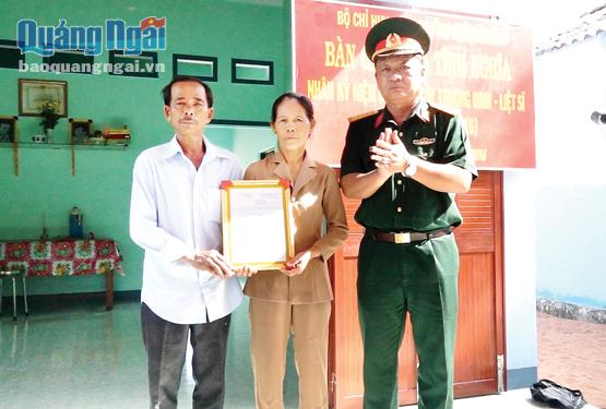 Đại tá Trần Xi Noa - Phó Chính ủy BCHQS tỉnh trao quyết định tặng nhà cho bà Nguyễn Thị Chút.                                                                                            ảnh: Thành Duy