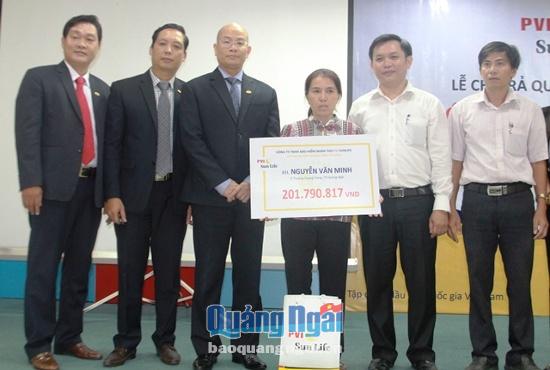 Đại diện công ty trao tiền chi trả cho gia đình anh Nguyễn Văn Minh.