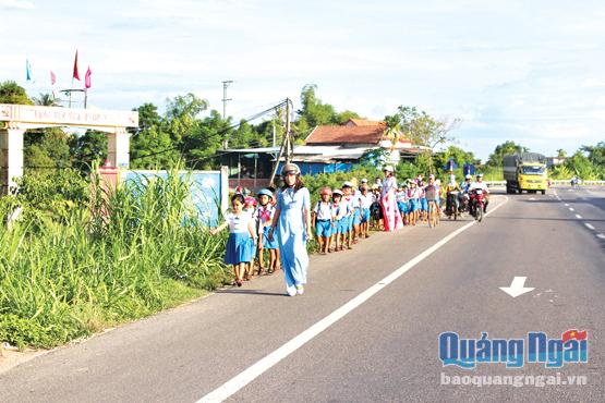  Gần 25 năm qua, mỗi buổi tan trường, các thầy cô giáo Trường Tiểu học Mỏ Cày đều hướng dẫn các em qua đường.