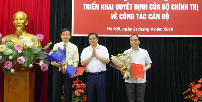 Đồng chí Phạm Minh Chính trao Quyết định của Bộ Chính trị cho đồng chí Đoàn Minh Huấn (bên trái) và đồng chí Vũ Văn Phúc (bên phải) - Ảnh Dangcongsan.vn