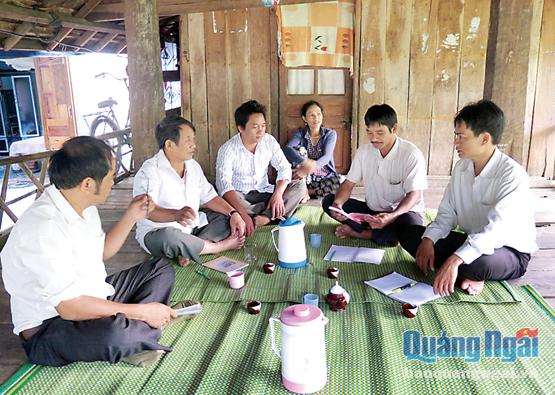 Bí thư Đảng ủy xã Ba Dinh Phạm Văn Thật (bên phải) trao đổi công việc với cán bộ thôn Đồng Dinh.