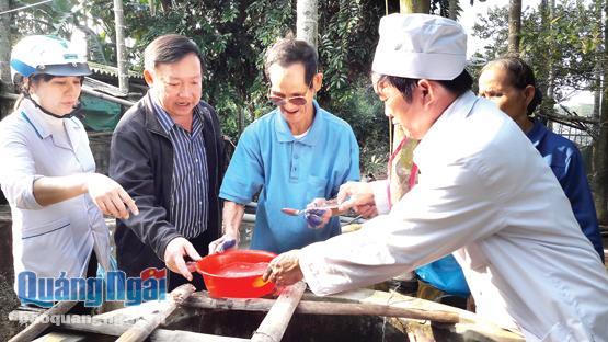 Cán bộ y tế dự phòng huyện Tư Nghĩa hướng dẫn người dân khử khuẩn nước giếng.                                                                                             ẢNH: kim ngân