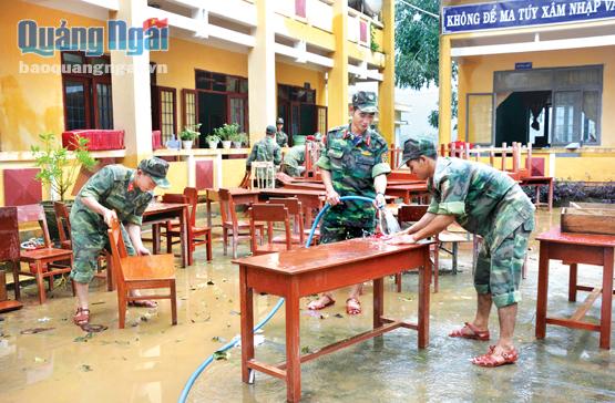 Cán bộ chiến sĩ lực lượng vũ trang tỉnh tham gia khắc phục hậu quả mưa lũ tại Trường Tiểu học Hành Tín Tây (Nghĩa Hành). ảnh: x.thiên