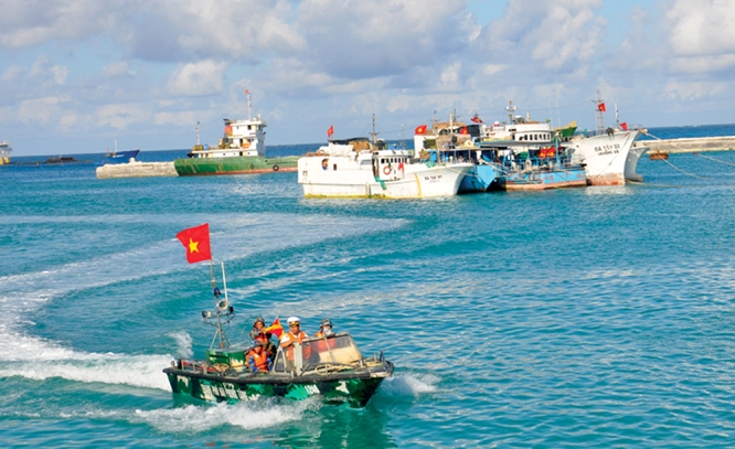Cờ Tổ quốc rực rỡ trên xuồng tuần tra và tàu ngư dân bám biển tại đảo Đá Tây A. ảnh: internet