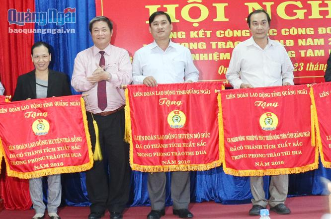 Chủ tịch LĐLĐ tỉnh Trần Văn Thanh tặng Cờ thi đua xuất sắc cho LĐLĐ huyện Trà Bồng. ảnh:  BS