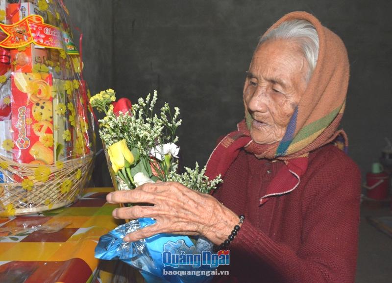 Bà Phú nâng niu bó hoa mà chính quyền địa phương tặng nhân ngày về nhà mới. Đây là bó hoa đầu tiên trong đời bà nhận được.