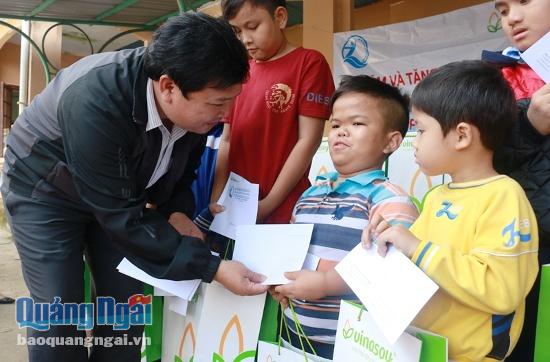 Giám đốc Quỹ bảo trợ trẻ em tỉnh Bùi Đức Thọ trao quà cho trẻ em ở Trung tâm phục hồi chức năng Hành Thiện (huyện Nghĩa Hành).