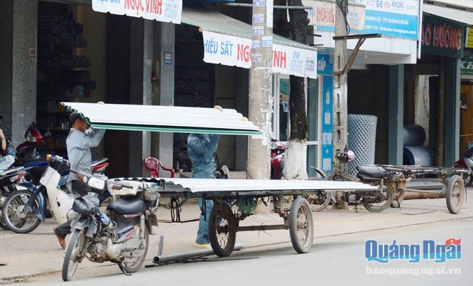 Xe máy chở vật liệu xây dựng tại một cửa hàng nằm trên đường Quang Trung (TP.Quảng Ngãi).    