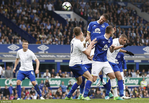 Phil Jagielka (áo xanh, bên trái) đánh đầu hạ Schmeichel, nâng tỷ số lên 3 - 2 cho Everton. Ảnh: Reuters