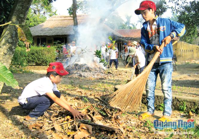 Học sinh ở huyện Nghĩa Hành tham gia dọn vệ sinh quanh nhà lưu niệm cụ Huỳnh.