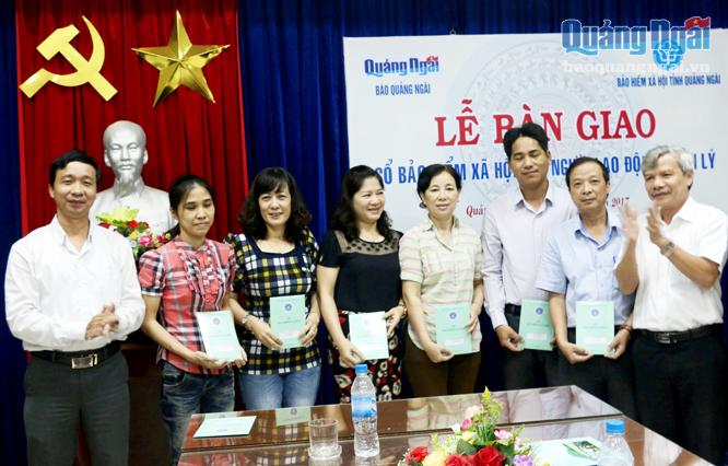 Đại diện lãnh đạo Báo Quảng Ngãi và BHXH tỉnh trao sổ BHXH cho cán bộ, viên chức Báo Quảng Ngãi.