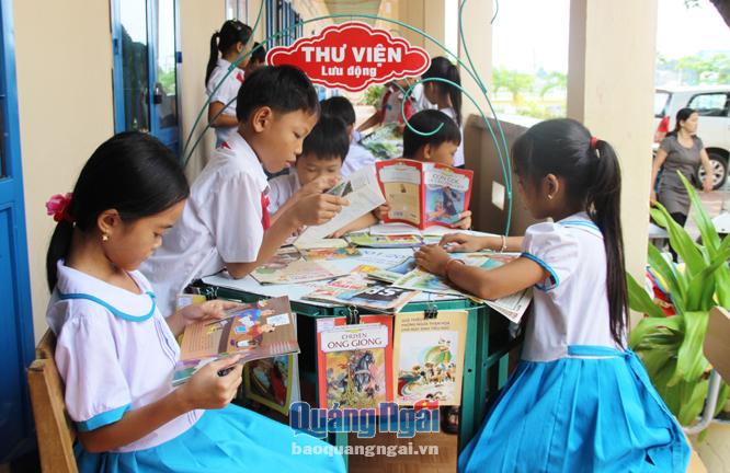 Các em học sinh Trường Tiểu học số 2 Bình Châu  (Bình Sơn) thoải mái chọn sách, báo để đọc khi mô hình thư viện được ra đời.