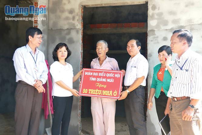 Phó trưởng đoàn chuyên trách Đoàn ĐBQH tỉnh Phạm Thị Thu Trang trao tiền hỗ trợ làm nhà mới cho gia đình ông Trần Đức Có.