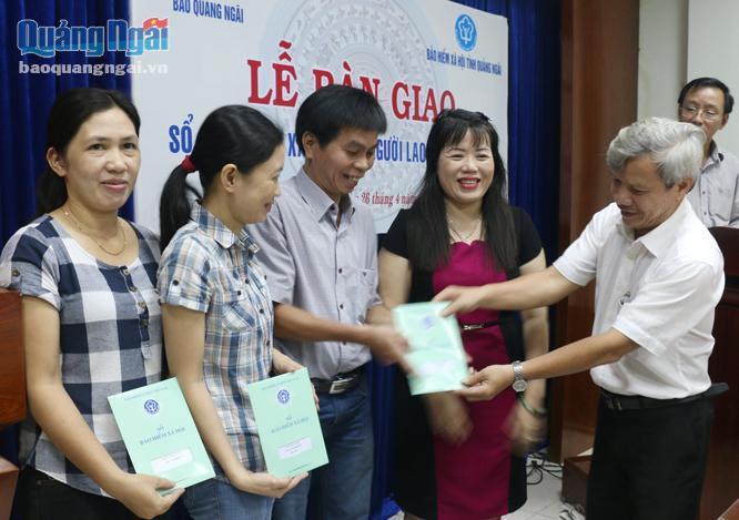 Phó giám đốc BHXH tỉnh Tiêu Sinh trao sổ BHXH cho cán bộ, nhân viên Báo Quảng Ngãi.