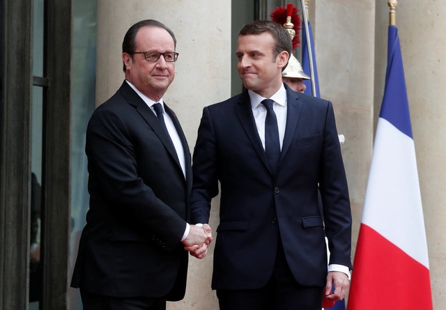Ông Hollande (trái) bắt tay ông Marcon - chủ nhân kế tiếp của điện Elysee (Ảnh: Reuters)