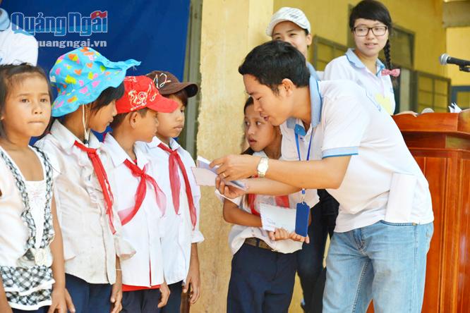 Anh Huỳnh Văn Thương tặng quà cho trẻ em nghèo miền núi trong hoạt động thiện nguyện của mình và cộng sự.