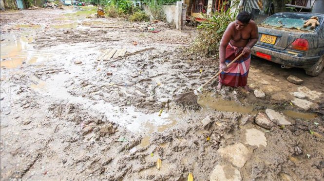 Người dân ở Wellampitiya, gần Colombo, Sri Lanka bắt tay dọn dẹp sau khi nước lũ bắt đầu rút - Ảnh: Anadolu