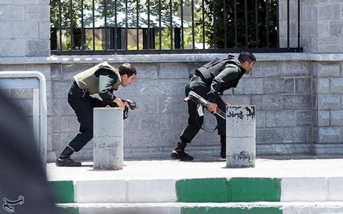  Hai binh sĩ thuộc lực lượng an ninh Iran áp sát khu vực xảy ra vụ tấn công khủng bố ở thủ đô Tehran. Ảnh: Reuters