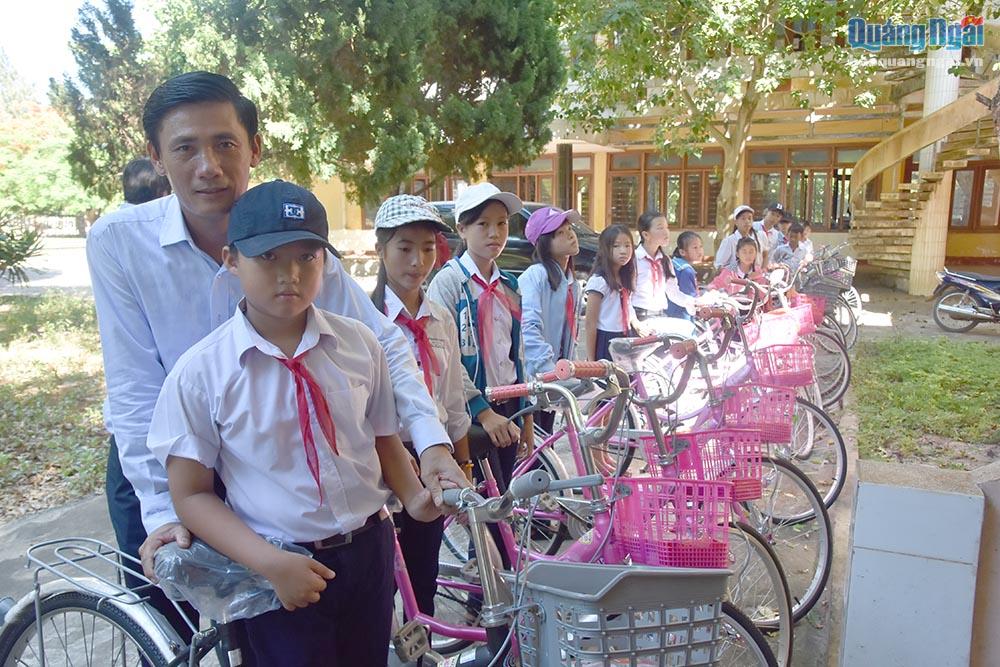 Đại diện Công ty Chín Nghĩa trao tặng xe đạp cho các em học sinh
