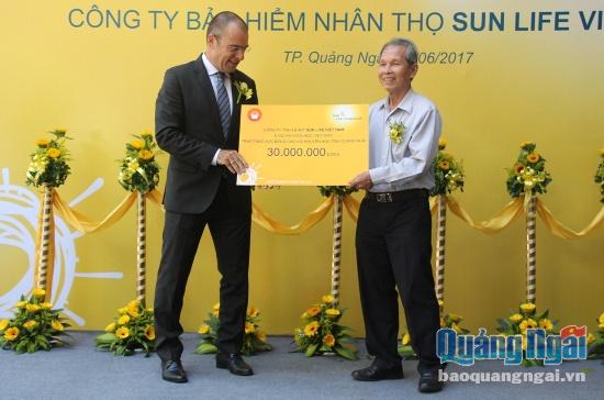 Ông Larry Madge- Tổng Giám đốc Sun Life Việt Nam trao tấm séc tượng trưng trị giá 30 triệu đồng cho Hội khuyến học tỉnh để hỗ trợ các em học sinh có thành tích học tập tốt.