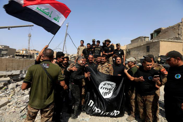  Lực lượng Chống khủng bố Iraq (CTS) cầm cờ của IS (màu đen) ăn mừng chiến thắng tại thành phố Mosul (Ảnh: Reuters)