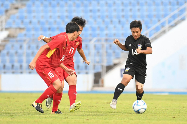 Các tuyển thủ U15 Việt Nam (áo đỏ, bên trái) ngăn chặn pha đi bóng của cầu thủ U15 Thái Lan (áo đen, bên phải)
