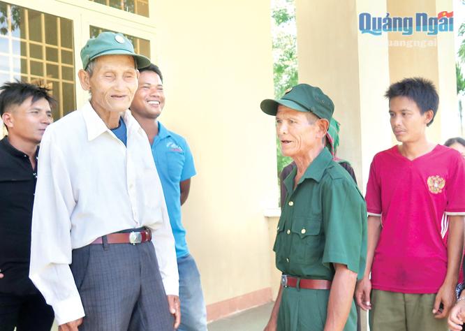 Cựu chiến binh Đinh Văn Nuông (thứ hai từ phải sang) nói chuyện với đồng đội và thanh niên tại Nhà văn hóa thôn.                            Ảnh: T.THUẬN