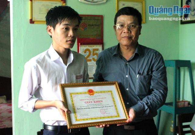 Ông Đỗ Văn Phu- Giám đốc Sở GD&ĐT  tặng Giấy khen cho em Quang.