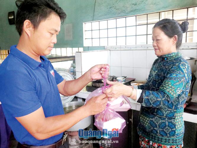 Thành viên CLB “Sống đẹp” nhận cơm của cô Châu phát cho các cụ già neo đơn ở xã Bình Trung.
