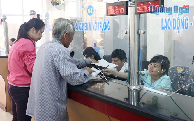 Cán bộ Trung tâm hành chính công huyện Bình Sơn giải quyết TTHC cho người dân.