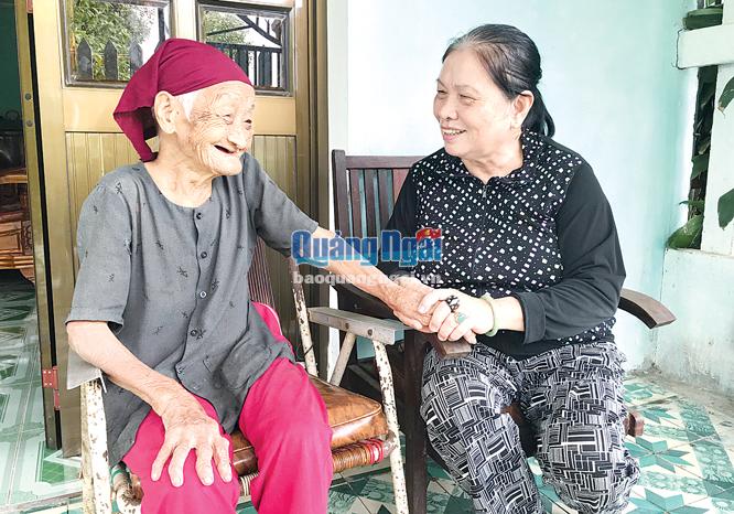 Bà Nguyễn Thị Lệ Thu (bên phải), ở phường Nghĩa Chánh (TP.Quảng Ngãi) thường xuyên đến thăm, trò chuyện và hỗ trợ hằng tháng cho cụ Nhớ.