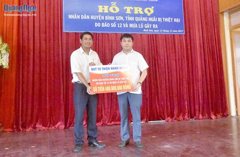 Đại diện nhà tài trợ trao bảng tượng trưng hỗ trợ 400 triệu đồng cho người dân vùng lũ huyện Bình Sơn