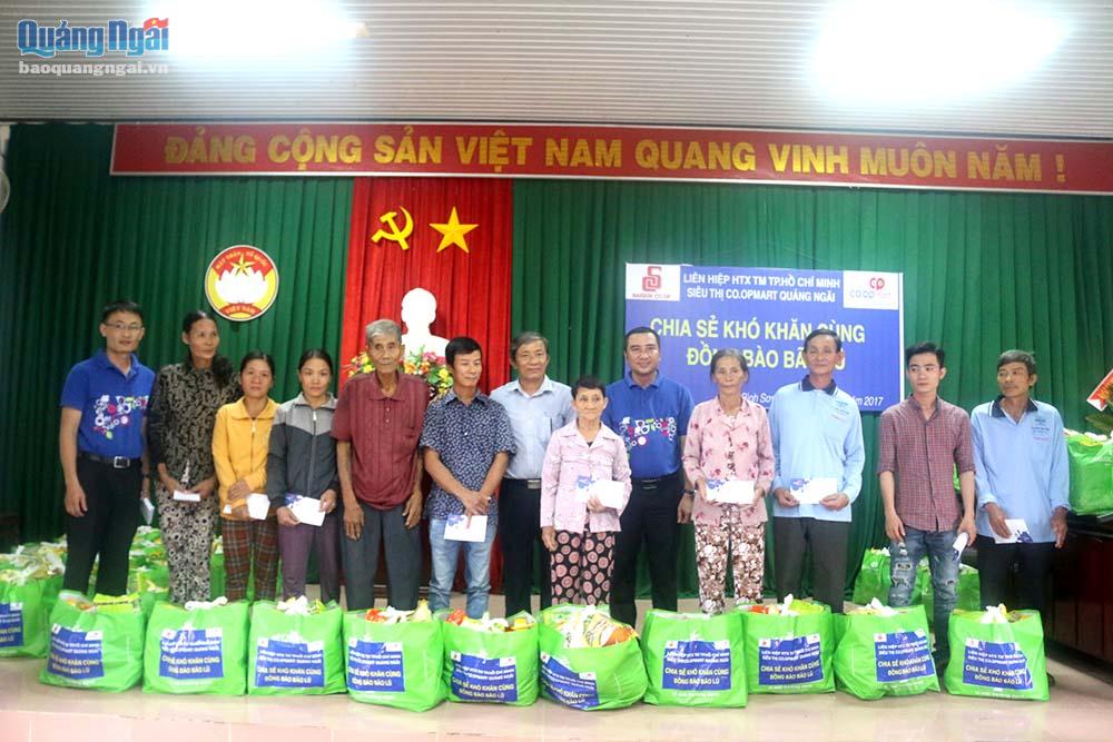 Đại diện Siêu thị Coop Mart Quảng Ngãi và UBMTTQVN tỉnh trao tặng quà cho người dân vùng lũ