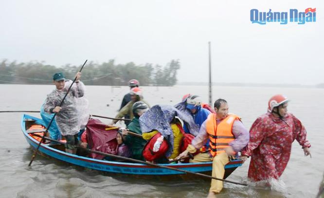Lực lượng dân quân di dời dân vùng ngập lũ thôn Châu Me, xã Bình Châu (Bình Sơn) trong đợt mưa lũ vừa qua.    
