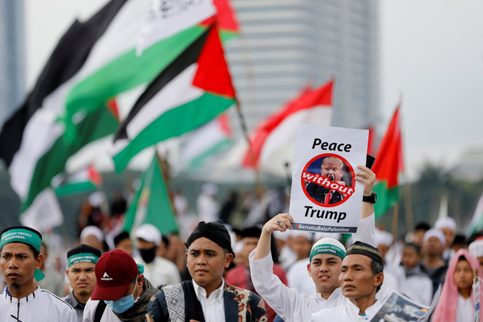 Người biểu tình giơ biểu ngữ "Hòa bình không cần Trump" - Ảnh: REUTERS