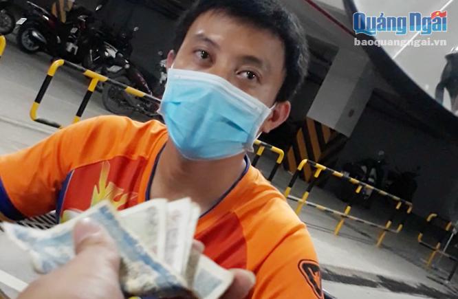 Điểm giữ xe tại chợ Quảng Ngãi liên tục xảy ra tình trạng thu phí sai quy định. Trong ảnh: Thanh niên soát vé thu tiền chỉ trả lại cho khách 8.000 đồng, dù khách đưa 10.000 đồng (ảnh cắt từ clip).     